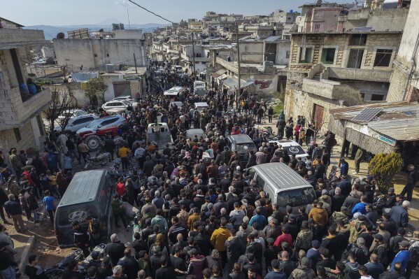 Los familiares y vecinos participan en la procesión fúnebre de cuatro miembros de la Fuerza de Seguridad Siria asesinadas en enfrentamientos con el leal del Presidente del Depósito Bashar Assad en la costa de Siria, en el pueblo de al-Janoudiya, al oeste de Idlib, sábado 8 de marzo, 2025. (AP Photo/Omar Albam)