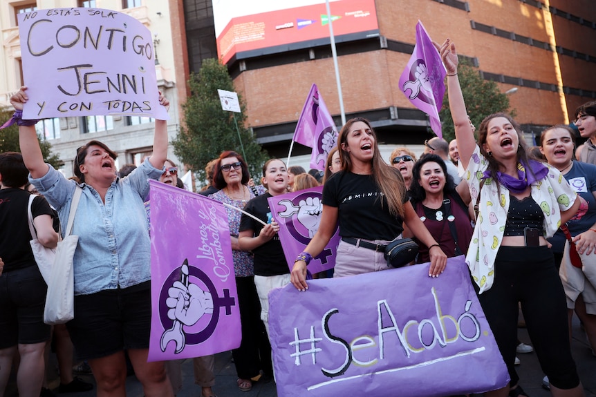 Un gran grupo de mujeres gritando y sosteniendo carteles. 