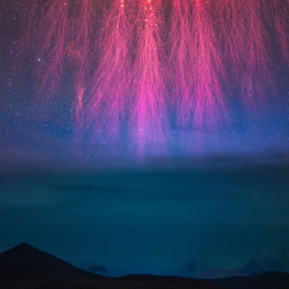 Una imagen espacial con fuegos artificiales rosas sobre un fondo azul con estrellas