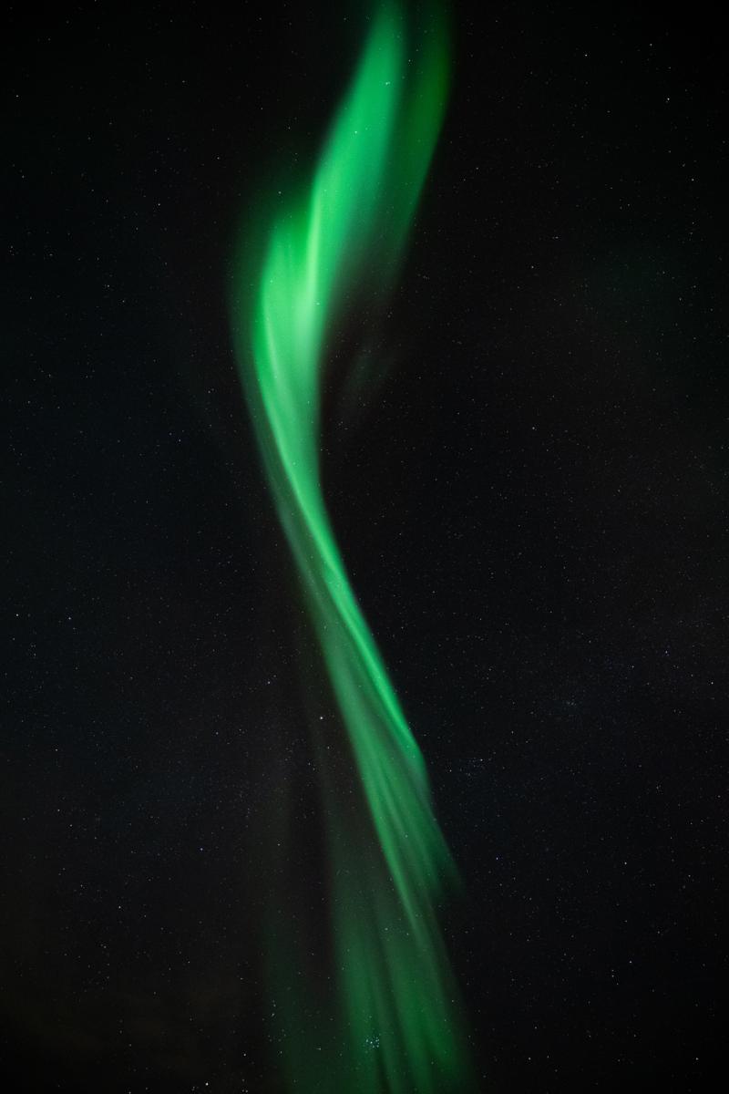 Una aurora verde que parece una pincelada en el cielo nocturno.