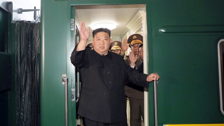 North Korean leader Kim Jong Un waves from a private train.