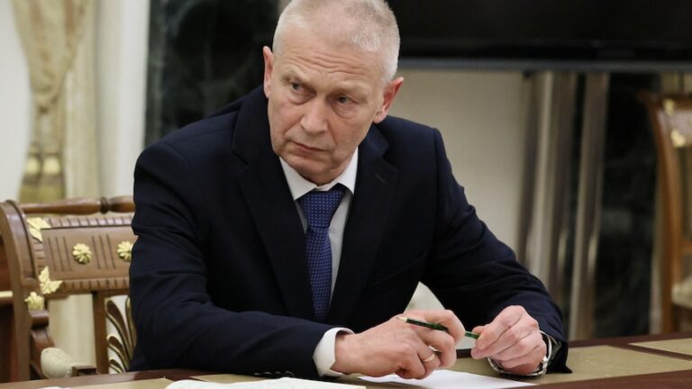 A man in suit attends a meeting.