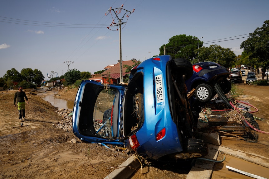 Coche azul volcado en el barro 