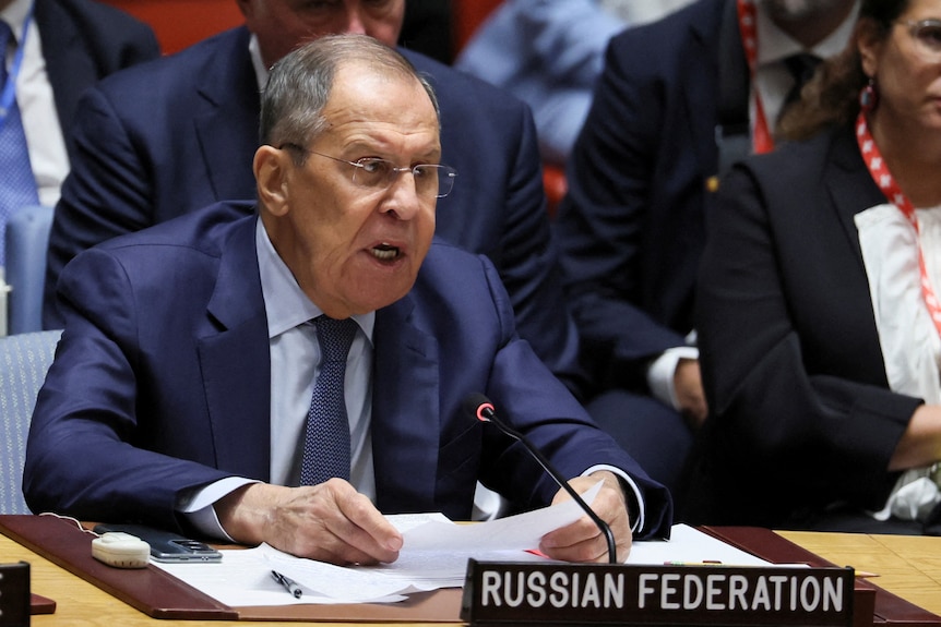 Sergei Lavrov está sentado detrás de un cartel que dice Federación Rusa.