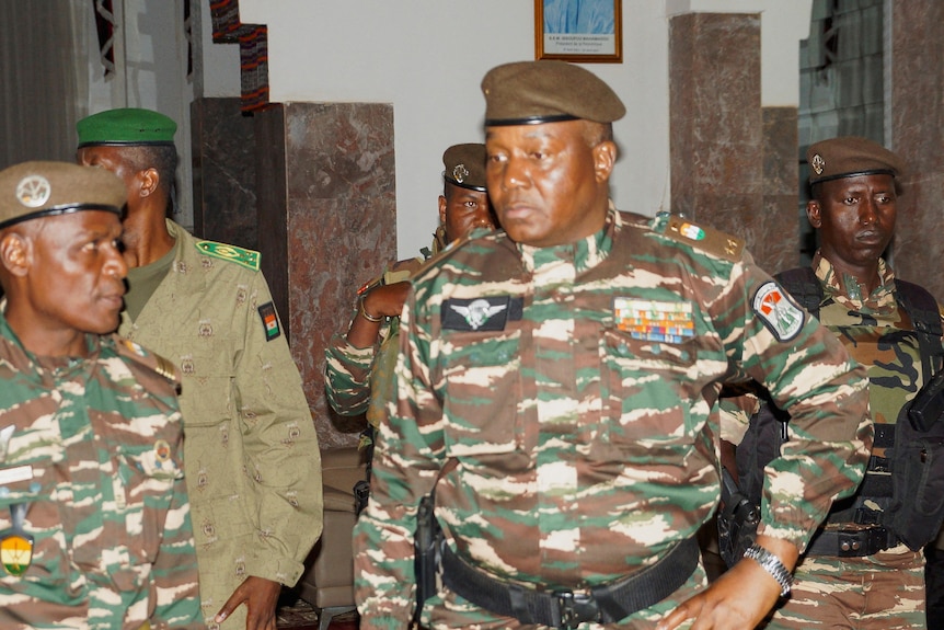 Abdourahmane Tiani con traje militar rodeado por otros cuatro hombres también con uniforme militar. 