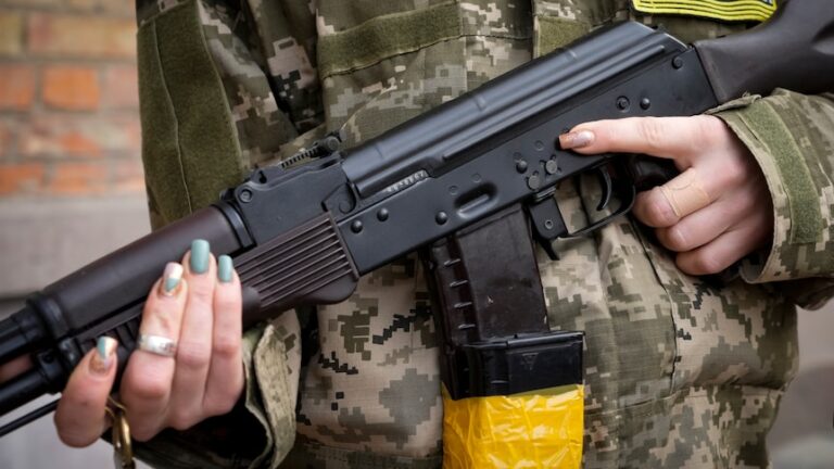 An armed civil defence woman in Kyiv holds a Kalashnikov rifle