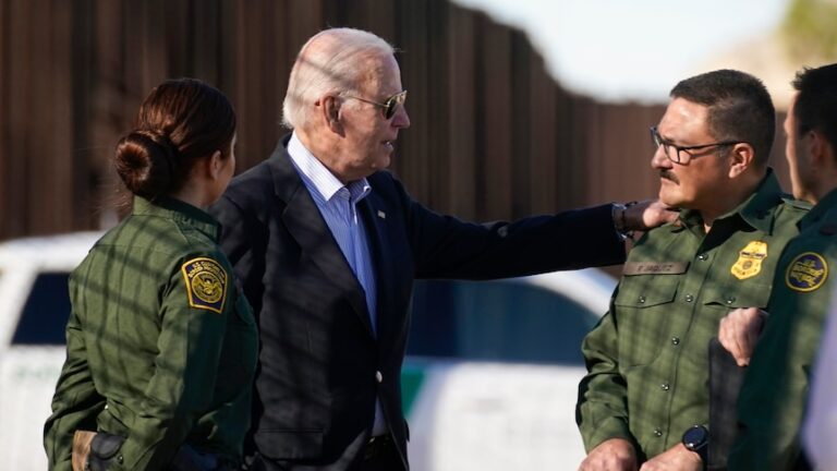 Mr Biden speaks with a man in unform and has his hand on his shoulder.