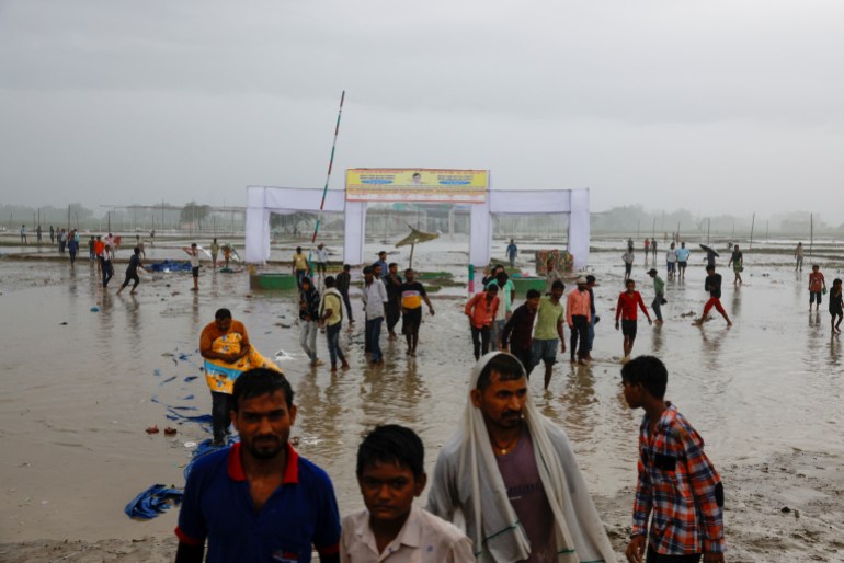 La gente camina en un campo, donde los fieles se reunieron para una congregación religiosa hindú, después de lo cual se produjo una estampida, en el distrito de Hathras del estado norteño de Uttar Pradesh.