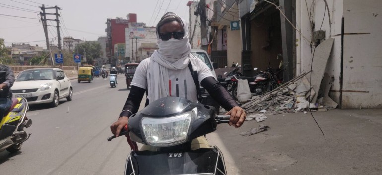 Govinda, de 27 años, se envuelve la cara con una tela blanca (gamchha) y usa gafas de sol para protegerse del calor.  Fotografía de Parthu Venkatesh.
