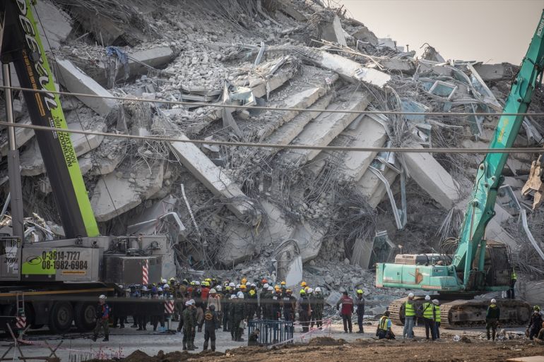 La gente está al lado de un edificio de colapso