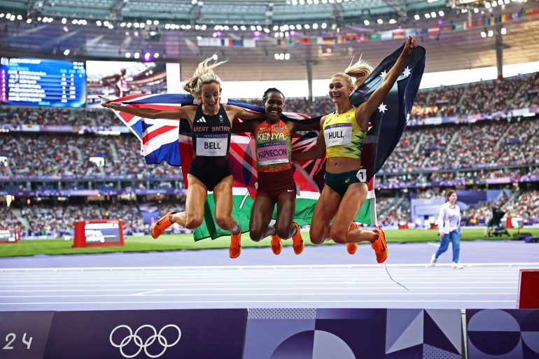 La medallista de bronce Georgia Bell de Gran Bretaña, la medallista de oro Faith Kipyegon de Kenia y la medallista de plata Jessica Hull de Australia celebran después de competir en la final femenina de 1500 m de la prueba de atletismo de los Juegos Olímpicos de París 2024, en el Stade de France, en Saint -Denis, al norte de París, el 10 de agosto de 2024. (Foto de Anne-Christine POUJOULAT / AFP)