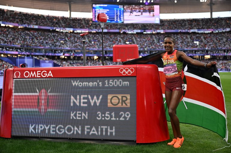 La medallista de oro keniana Faith Kipyegon posa en el marcador después de establecer un nuevo récord olímpico en la final femenina de 1.500 m de la prueba de atletismo de los Juegos Olímpicos de París 2024 en el Stade de France en Saint-Denis, al norte de París, el 10 de agosto de 2024. ( Foto de Kirill KUDRYAVTSEV / AFP)