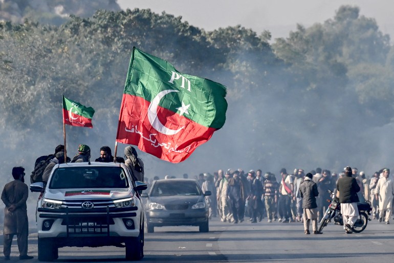 Los partidarios del partido Pakistán Tehreek-e-Insaf (PTI) del ex primer ministro encarcelado Imran Khan marchan hacia Islamabad después de limpiar los contenedores colocados por las autoridades durante una manifestación exigiendo la liberación de Khan, en la provincia de Hasan Abdal de Punjab el 25 de noviembre de 2024. - La capital de Pakistán era bajo bloqueo total el 24 de noviembre, con corte de Internet móvil y miles de agentes de policía inundando las calles mientras los partidarios del ex primer ministro eran arrestados. marcharon sobre la ciudad. (Foto de Aamir QURESHI/AFP)