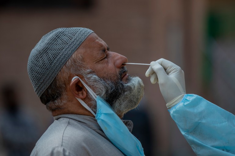 Un trabajador sanitario de Cachemira recoge una muestra de hisopo nasal para realizar pruebas de COVID-19 en Srinagar, Cachemira controlada por India, el martes 6 de octubre de 2020. India es el segundo peor país en términos de casos confirmados de coronavirus.  (Foto AP/Dar Yasin)