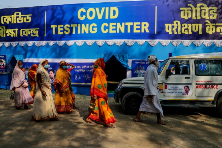 Un grupo de peregrinos hindúes que se dirigen a la peregrinación a Gangasagar pasa por un campo de pruebas temporal de COVID-19 en un campamento de tránsito en Calcuta, India, el domingo 10 de enero de 2021. Este año, debido a la pandemia, las autoridades anticipan un número menor de peregrinos durante la peregrinación anual que coincide con el festival Makar Sankranti que se lleva a cabo el 14 de enero.  (Foto AP/Bikas Das)