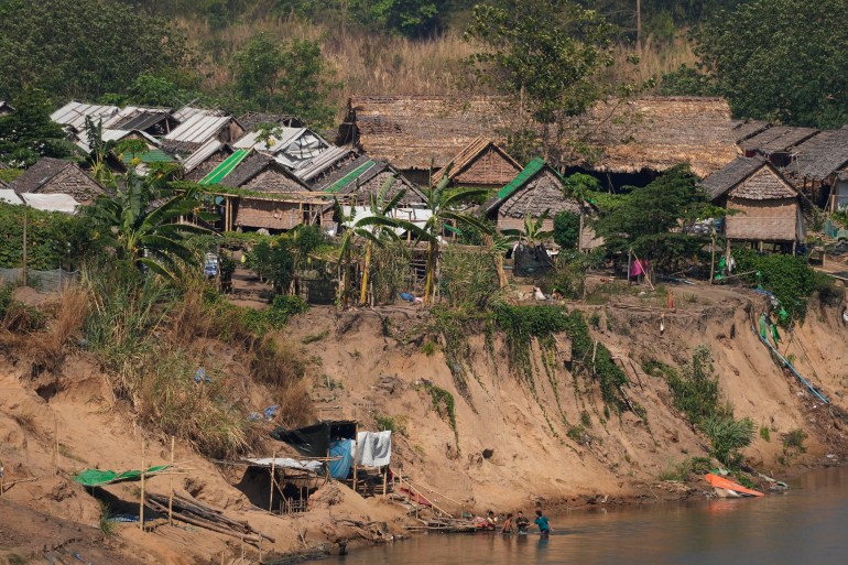 Vista de un campamento para personas desplazadas por los combates en Myanmar.  Está a orillas del río Moei, que separa Myanmar de Tailandia.  Los edificios están hechos de bambú y palmeras.