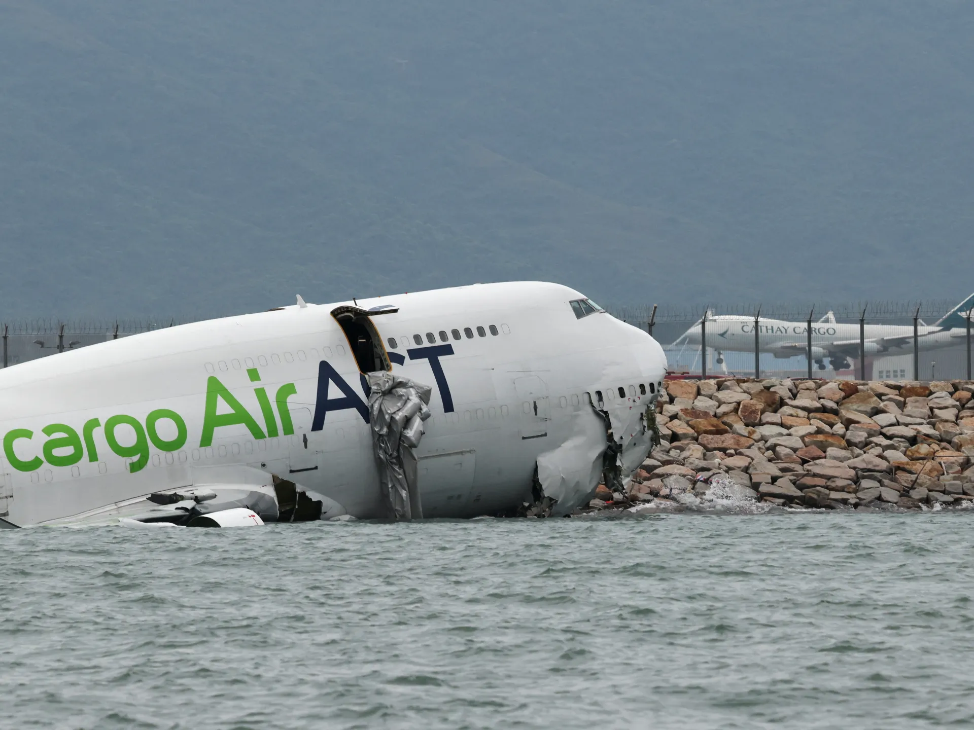 Cargo plane skids off Hong Kong runway into sea | Transport